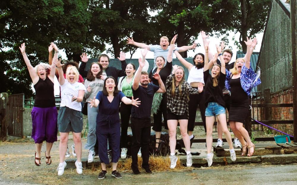 The Revolution Performing Arts team, including founder Fi Da Silva Adams (far left, purple skirt) and new leaders Louise Montague (second in from right in denim shorts) & Charlotte Simonis (camera right of Fi Da Silva Adams in white top, grey shorts, front row). 