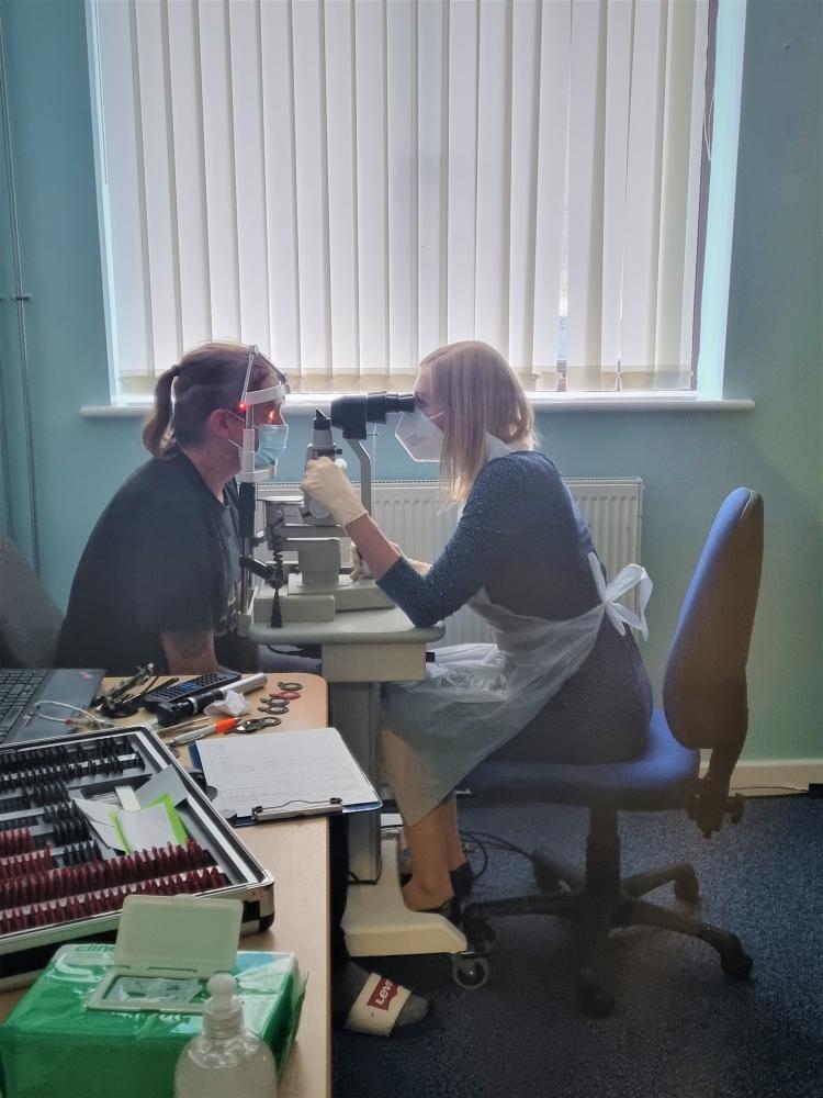 Anna Lewin, clinical lead optometrist at Haine & Smith, performing an eye examination on Alabaré client Terry   
