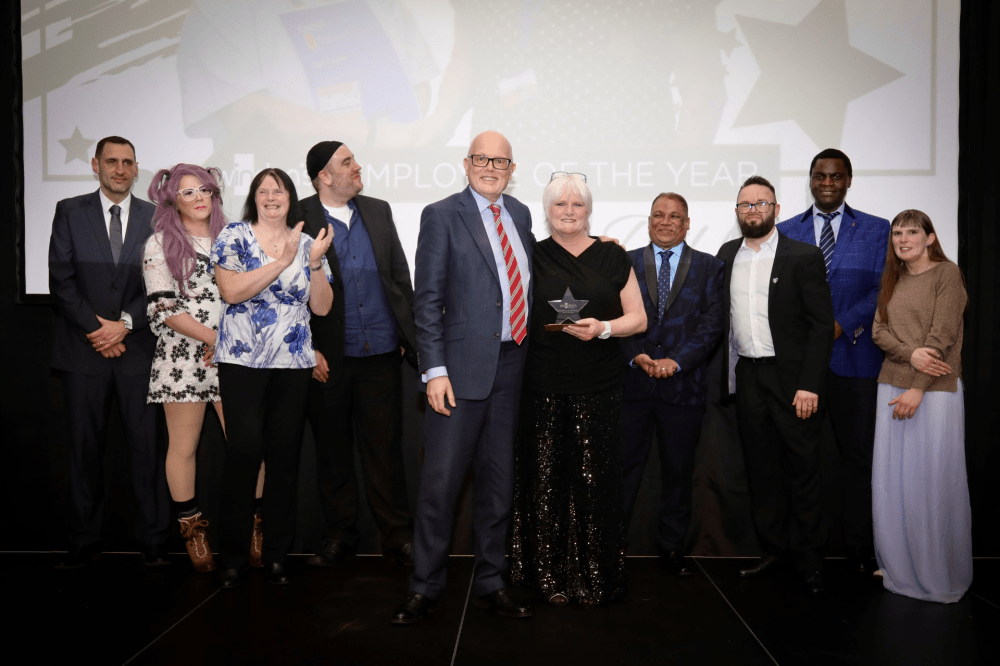 Del with colleagues, receiving her award from Andrew Wickham.