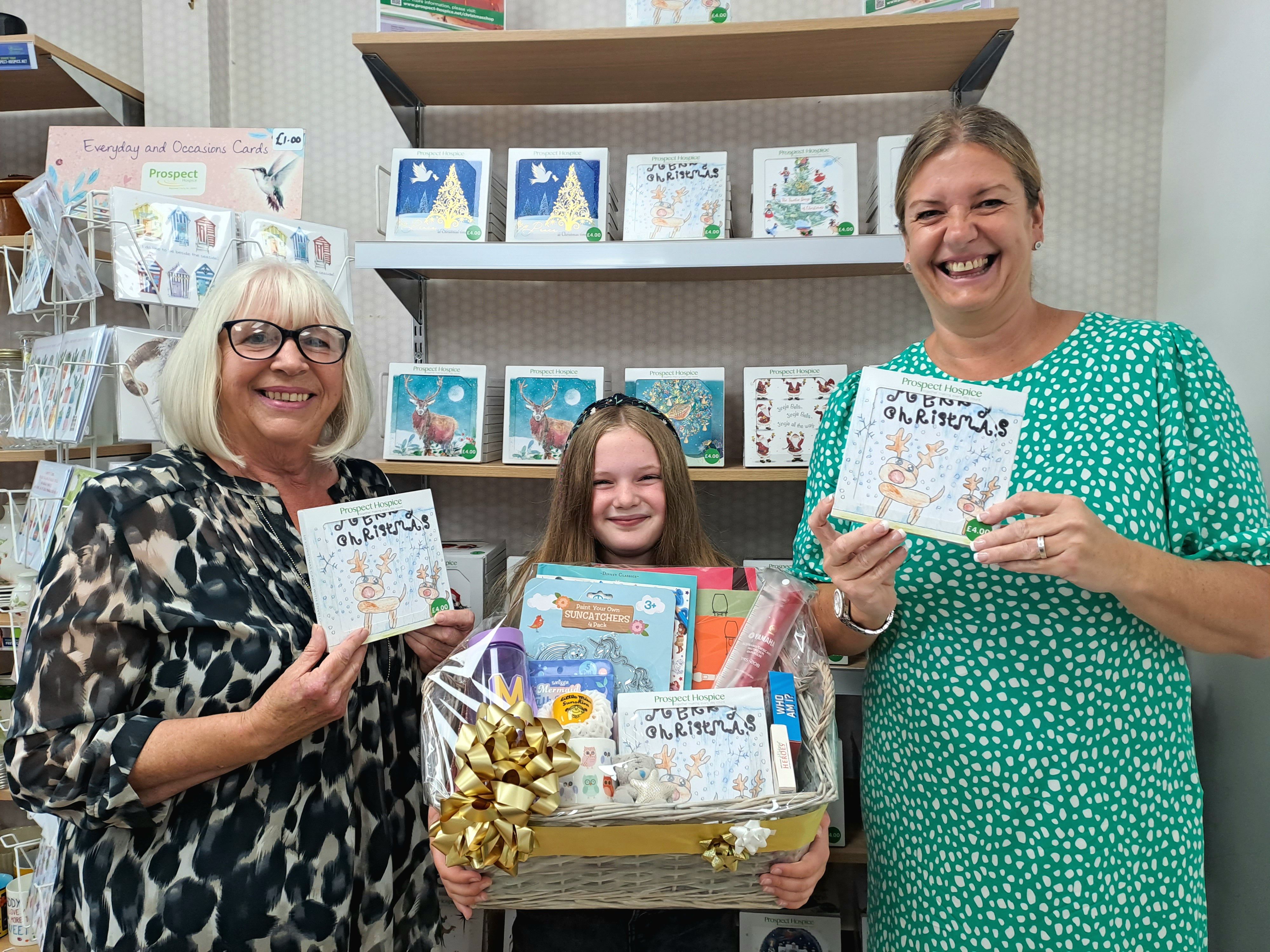 Matilda with her hamper. On her left is her grandmother, who volunteers at the Wroughton charity shop, and on her right is Victoria Canavan, Prospect Hospice's head of retail. 