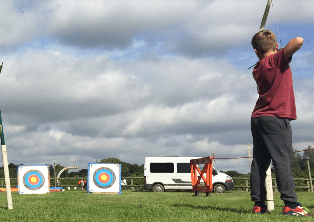 Archery is an example of one of the activities that YAW takes young people out to enjoy - the minibus can be seen pictured in the background
