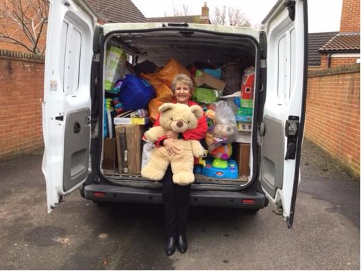 Linda Locke pictured on one of her collections with a van full of donations