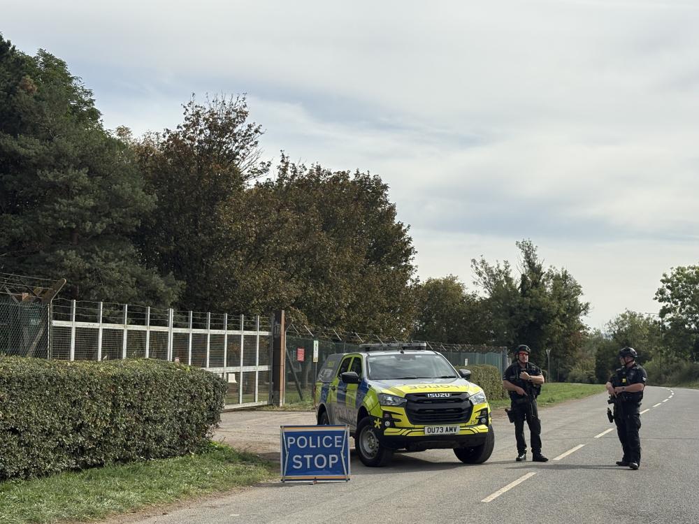 Armed police guard one of the entrances to the base, which is blocked on the other side by a large military vehicle