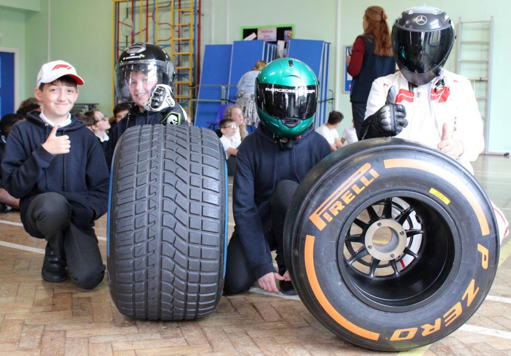 Year 6 students posing with helmets and tyres 