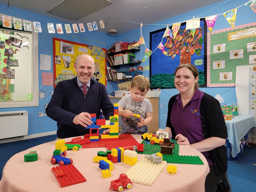 North Swindon MP Justin Tomlinson with Senior Care Practitioner Kam Deller and a young Lego enthusiast