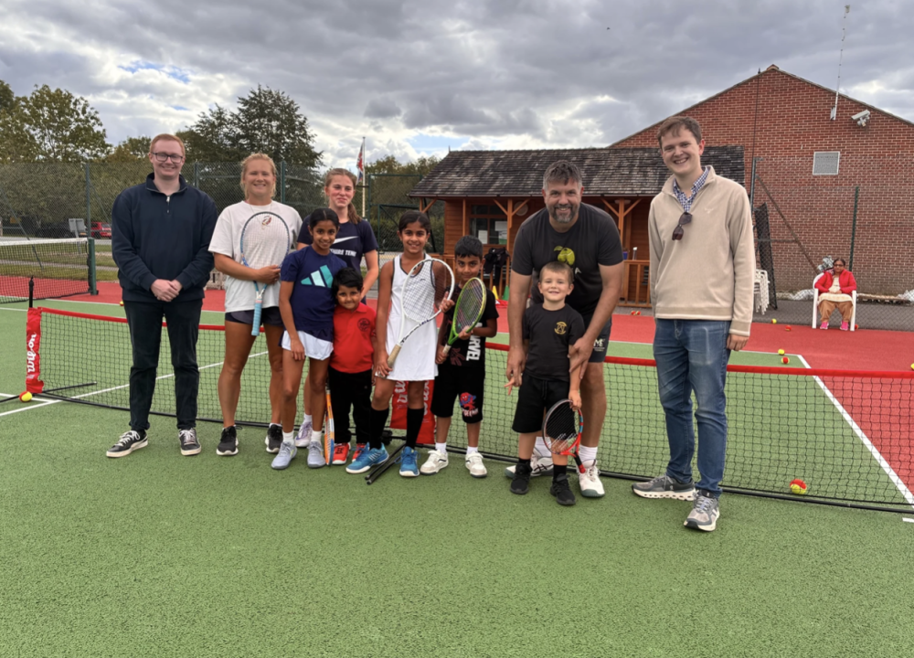 Cllr Matthew Vallender (far left) with Cllr Matt Hinton (far right) and Wanborough Tennis Club coaches Becky and Neil Watts with some of the club's young budding tennis stars