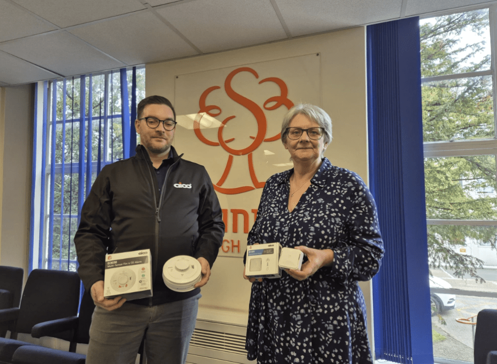 Cllr Janine Howarth with Peter Price-Higgott from Aico holding the new fire alarms and environment sensors