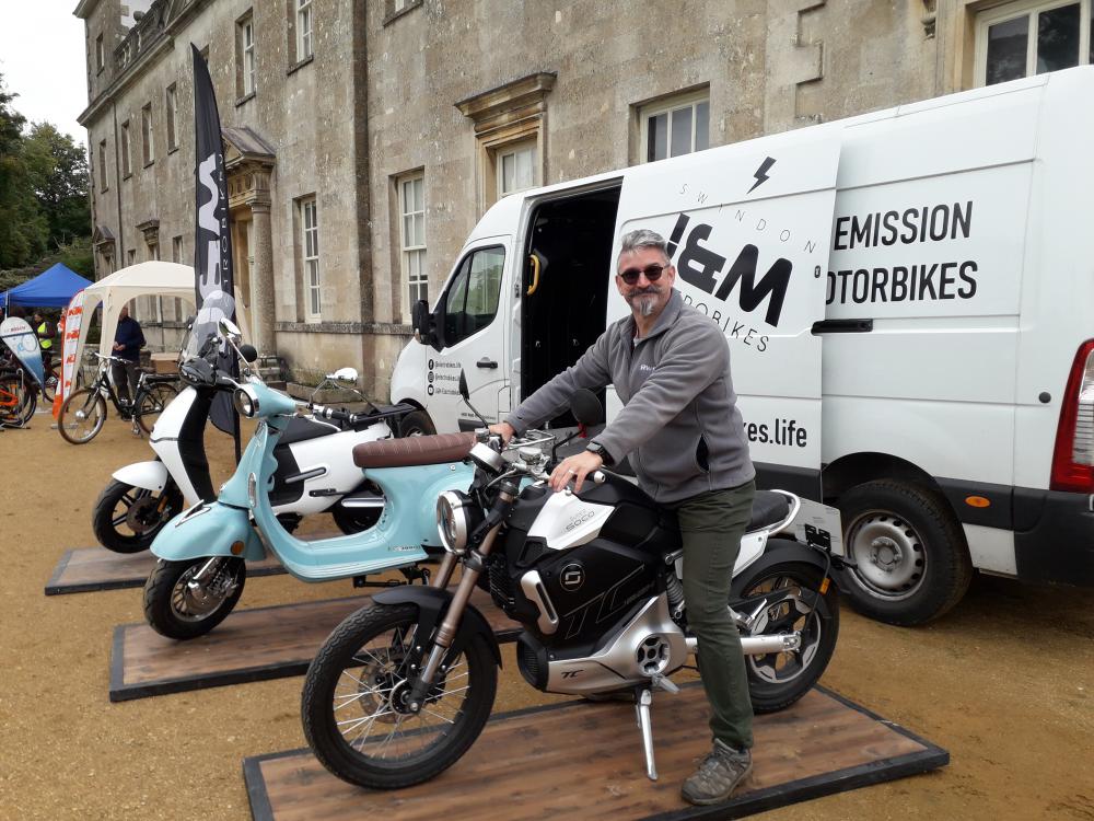 James Rens of J&M Electrobikes astride a Super Soko TC Max electric motorcycle. He also brought a vintage-style Artisan scooter and a more modern-looking Horwin scooter.