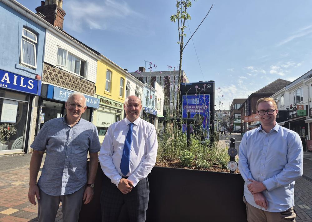  Local trader Vince Ayris, Cllr Kevin Parry, Cabinet Member for Recycling and Streetscene, and Cllr Matt Vallender, Cabinet Member for Culture, Planning and Regeneration, at the recently installed planters in Havelock Street