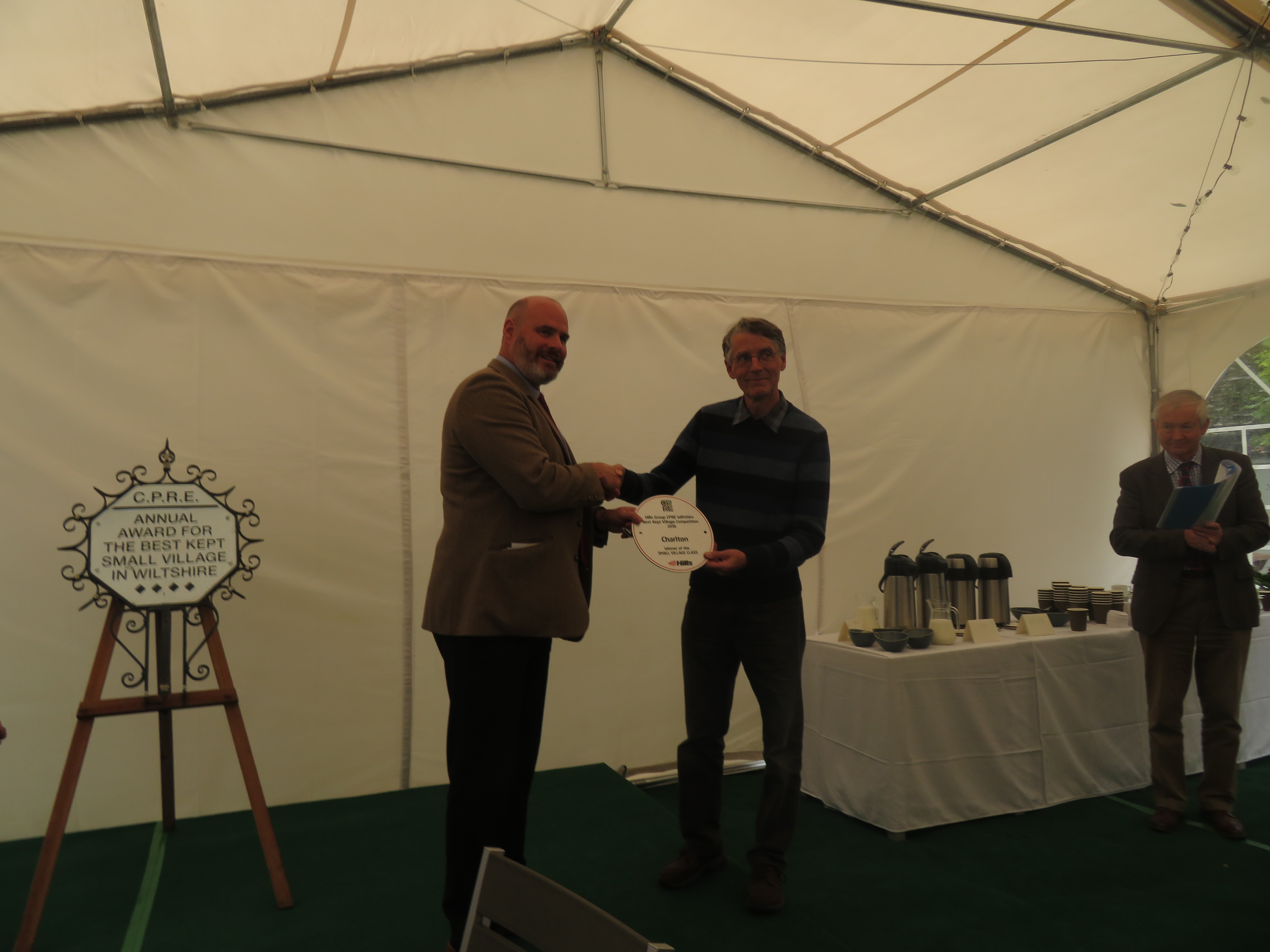 Mike Hill, Chief Executive of The Hills Group presents the plaque to Charlton's Peter Holland, editor of the local Village Chat